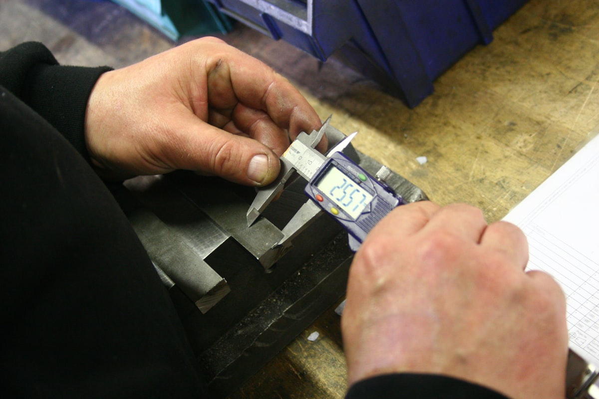 Ein Bauteil wird mit dem Messschieber geprüft